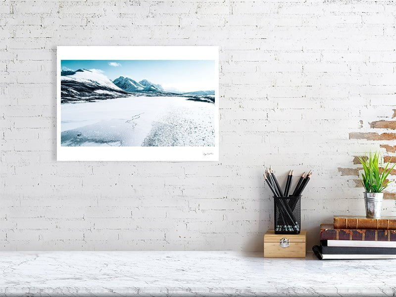Frozen Norwegian fjord photo print, snow-capped mountains in background, white living room wall.