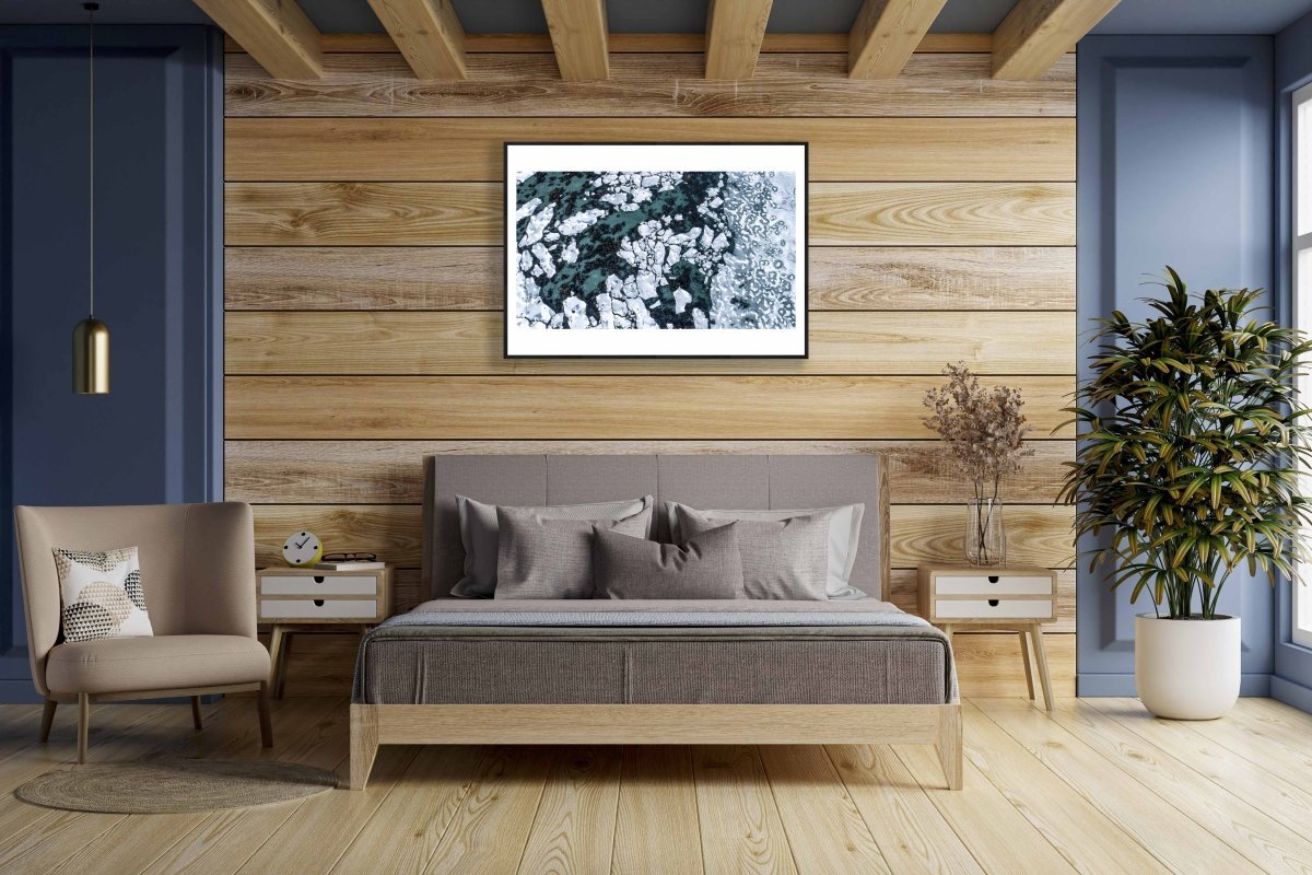 Framed aerial photo, Norwegian Sea, seabed visible between shards of ice, wooden bedroom wall.