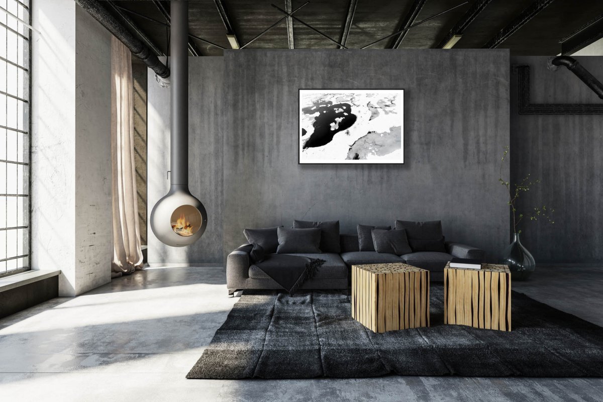 Framed aerial bog photo, contrasting frozen and thawed ponds, five stunted spruces, grey stone living room wall.