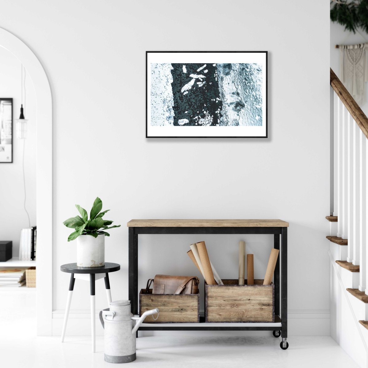 Framed aerial photo of icy Norwegian fjord with shattered ice floes, white living room wall.