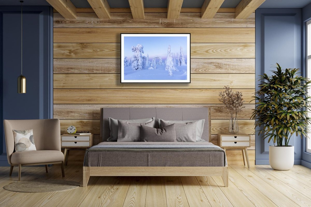 Framed photo of snowy fairy-tale trees in pastel Arctic landscape, wooden bedroom wall.