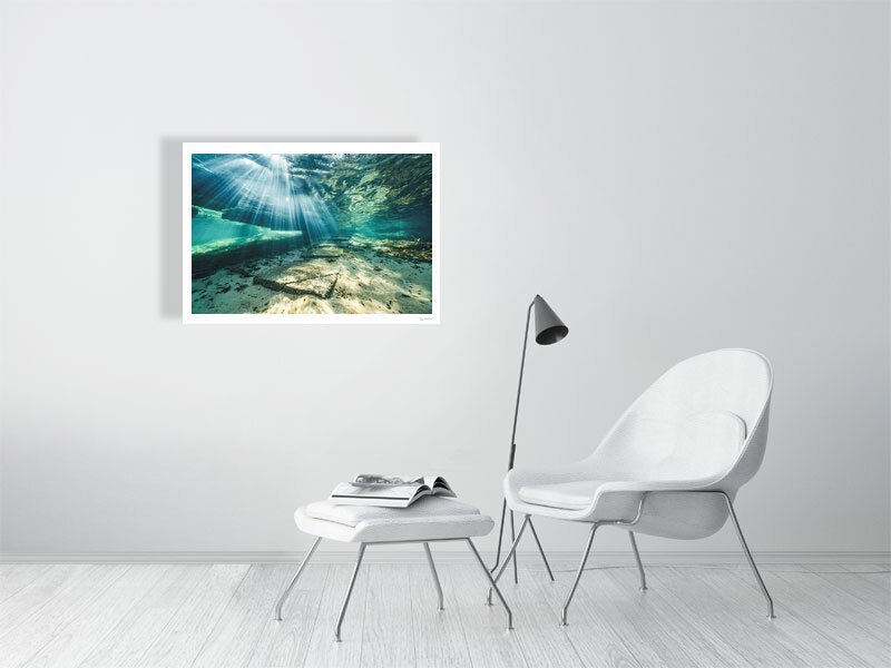 Photo print of sunlight shining through water, illuminating underwater steps, white living room wall.