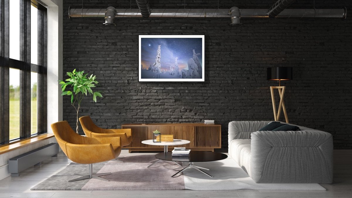 Framed photo of snow-draped trees in Riisitunturi fell, Finland, under starry sky, white living room wall.