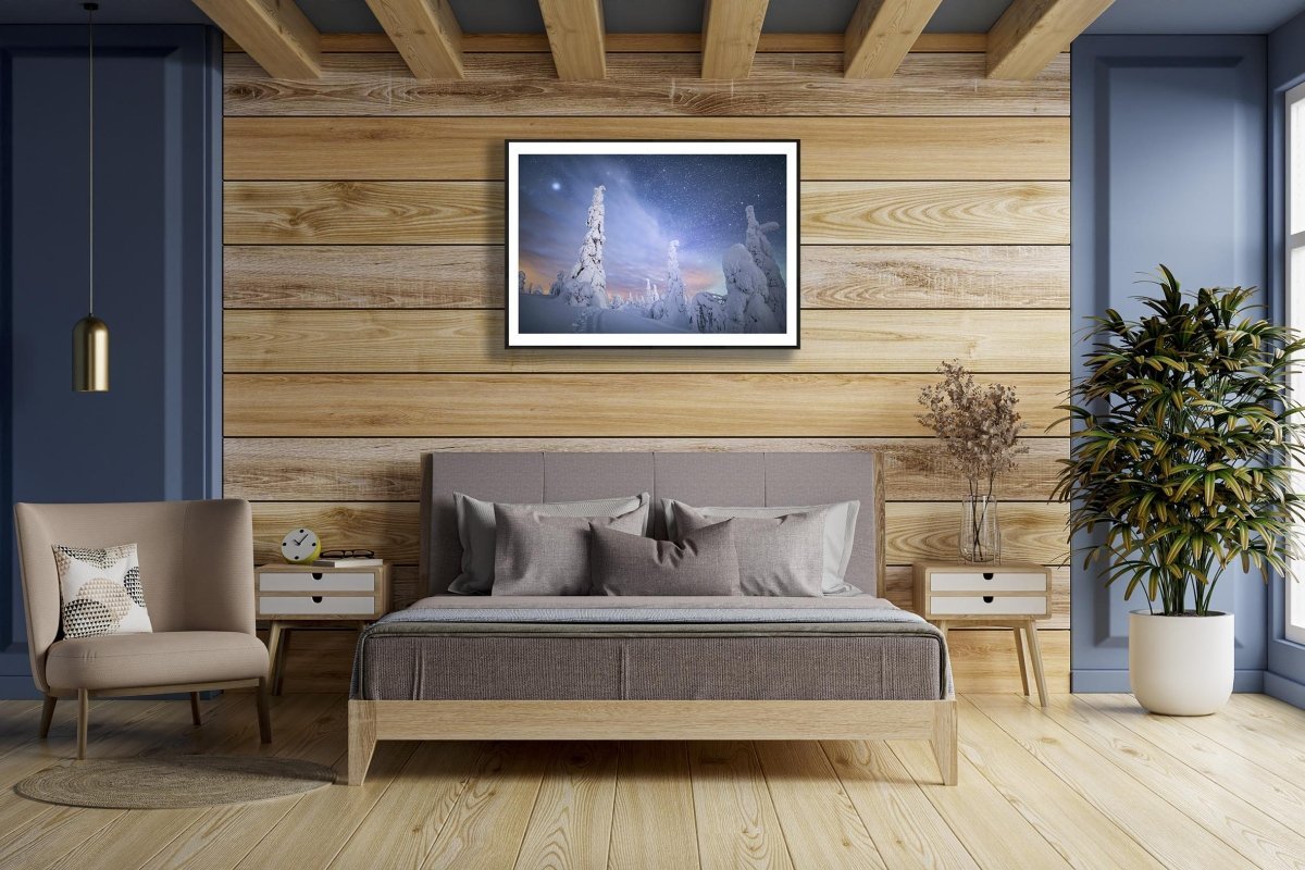 Framed photo of snow-draped trees in Riisitunturi fell, Finland, under starry sky, white living room wall.