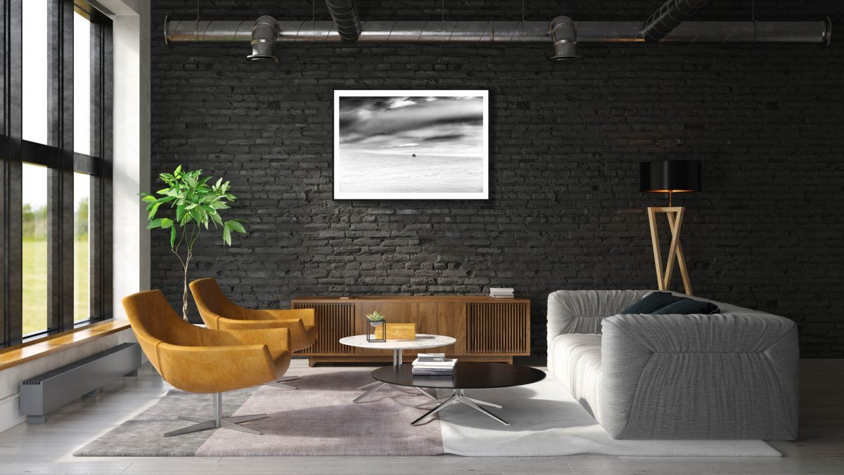 Framed black and white photo of mountain birch standing firm in frozen Arctic wilderness, black brick living room wall.