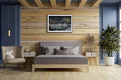 Framed photo of Northern Lights over steaming Arctic river, wooden bedroom wall above bed.