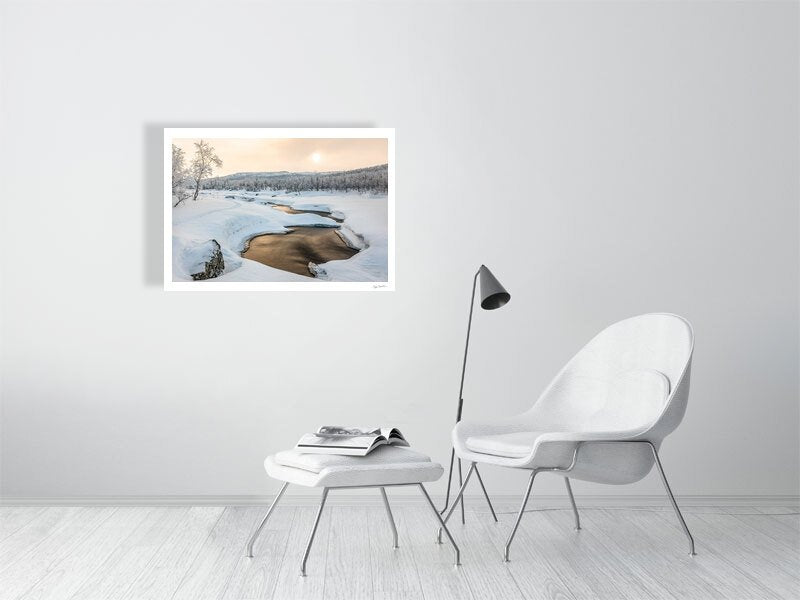 Arctic landscape fine art photo print of a frozen river and bronze-hued sunlight reflection, on white living room wall.