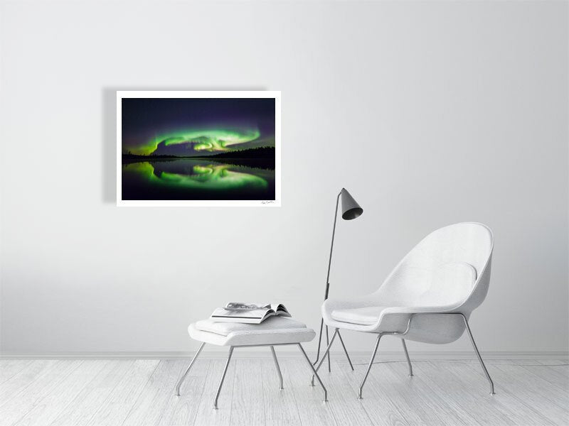 Fine art print of turtle-shaped Northern Lights reflections on the surface of a lake, displayed on white living room wall.