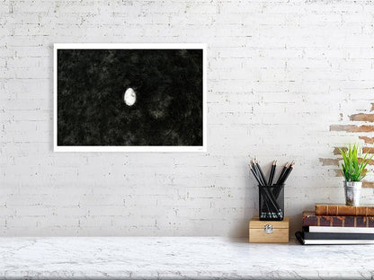 Fine art photography print of a broken egg lying at the bottom of the lake, displayed on a white wall in a living room.