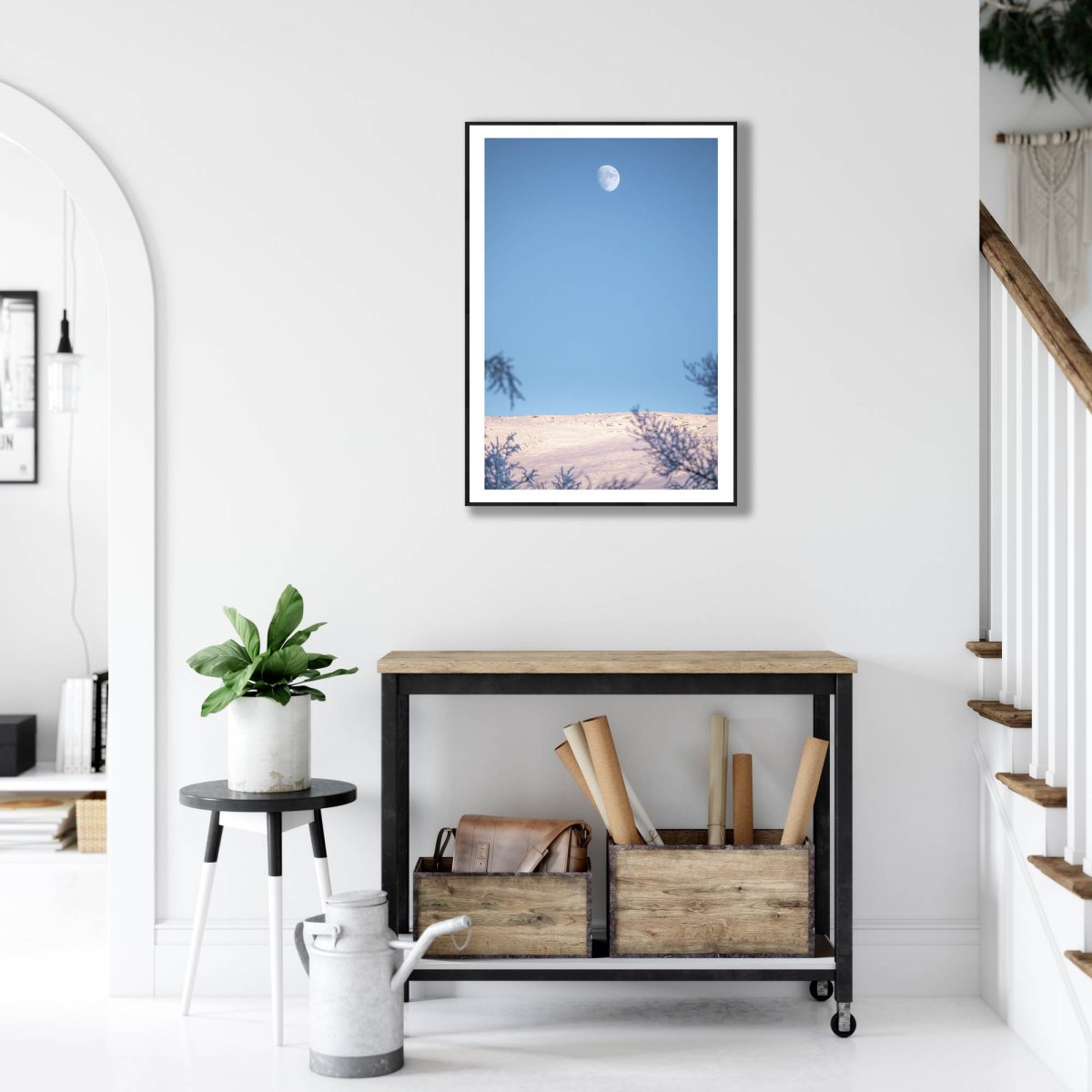 Black-framed Arctic landscape print, snow-covered fell, moon, white living room wall.