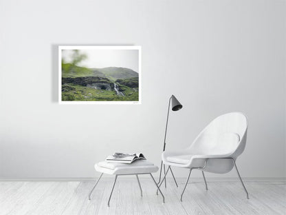 Photo print of Norwegian river winding past cave entrance in lush green mountains, white living room wall.