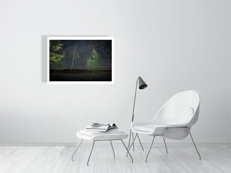 Fine art print of nocturnal forest and lakeside double exposure, displayed on white wall in living room.