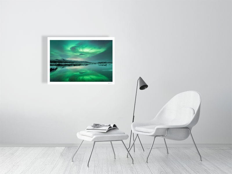 Fine art print of Northern Lights dance above a frozen lake, reflected in the calm waters, on white living room wall.