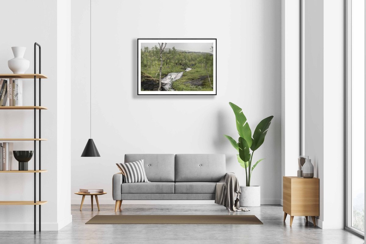 Framed Norwegian river print on white wall above sofa in modern living room.