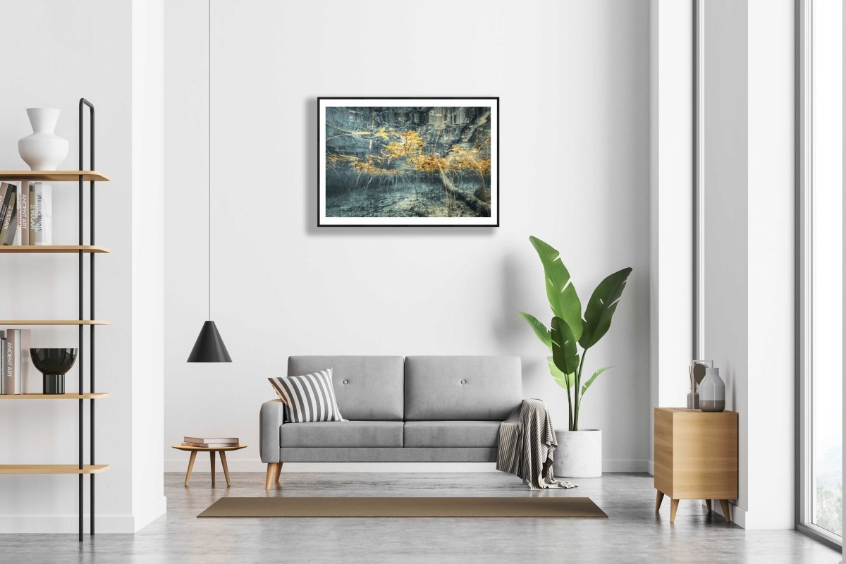 Framed underwater lake scene print, surreal yellow autumn plant reflections, white living room wall.