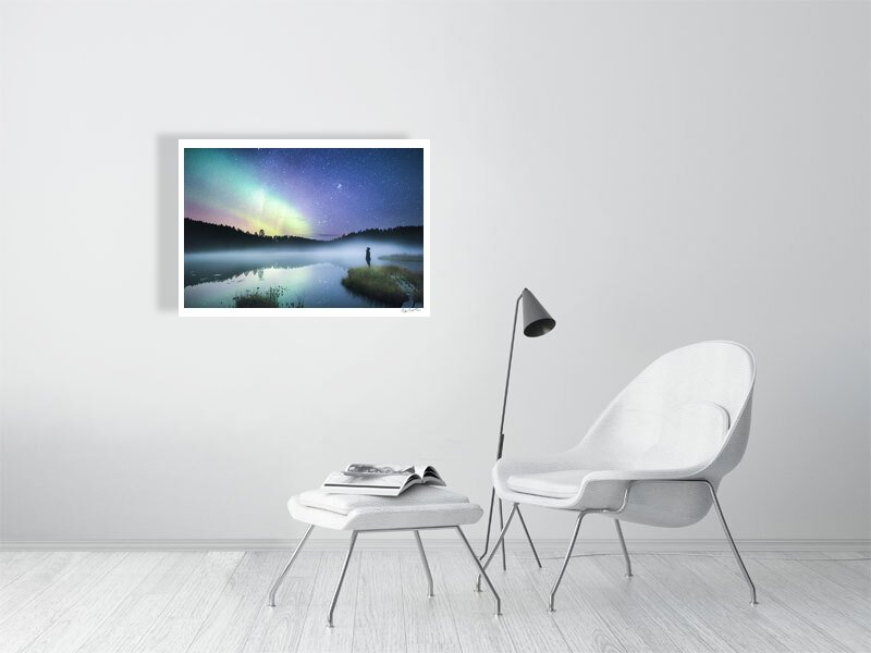 Fine art photography print of person in forest at night, reflecting Northern Lights and stars, on white wall in living room.