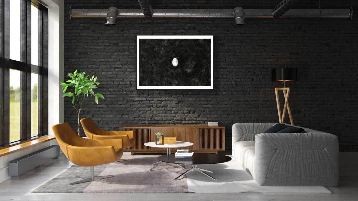 Framed fine art print of a broken egg lying at the bottom of the lake, on a black brick wall in a modern living room.