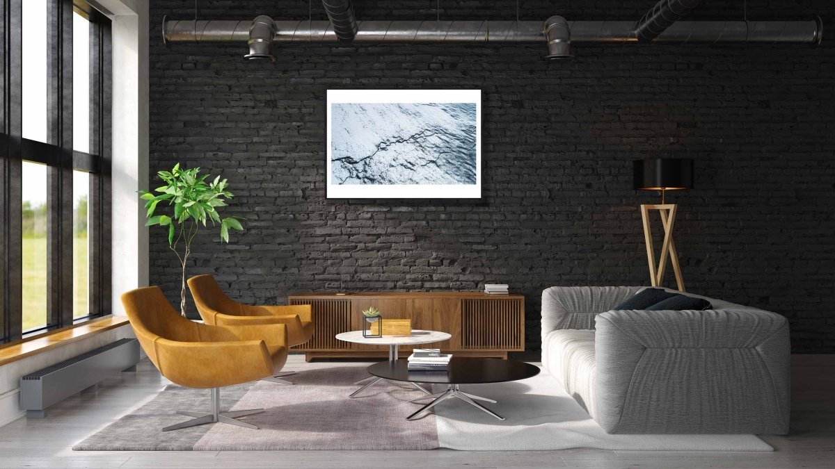 Framed Norway frozen ocean aerial photo print, cracked ice graphic pattern, modern black brick wall.