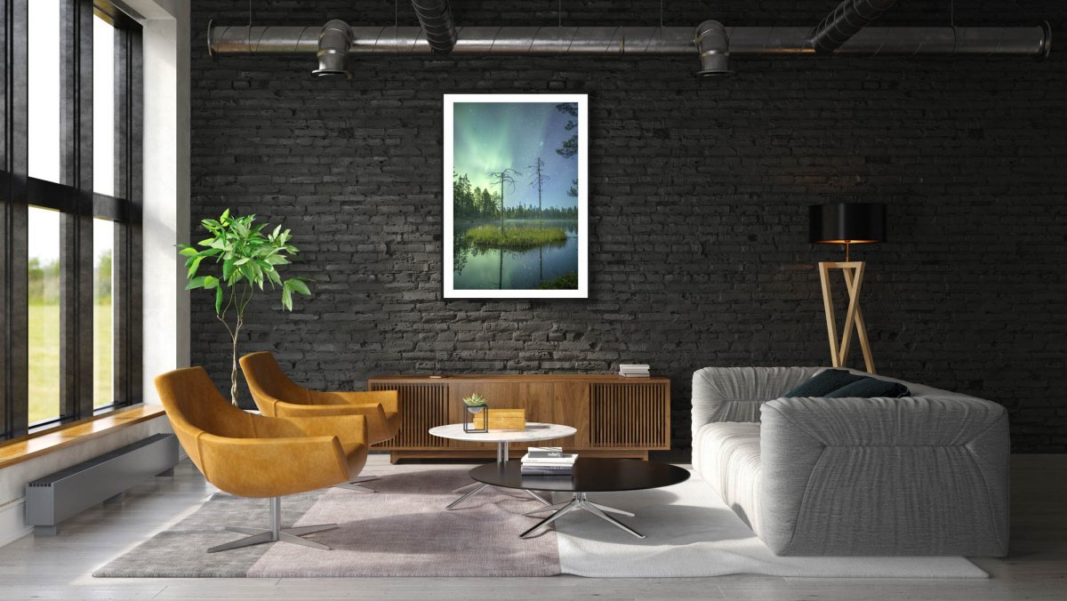 Framed photo, forest pond, island with two pines, Northern Lights and stars reflection, black brick living room wall.