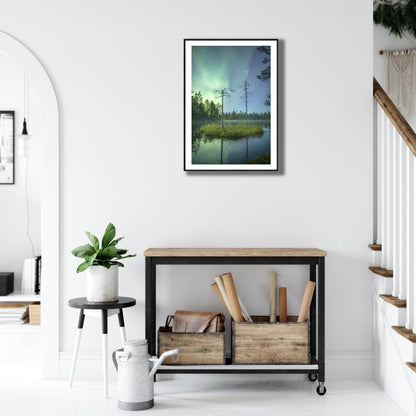 Framed autumn forest pond photo, island, ancient pines, Northern Lights, starlit sky, white living room wall above desk.