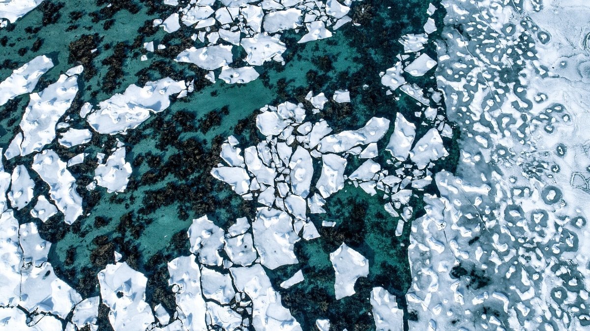 Aerial view of the Norwegian Sea, with the seabed visible between the shards of ice.