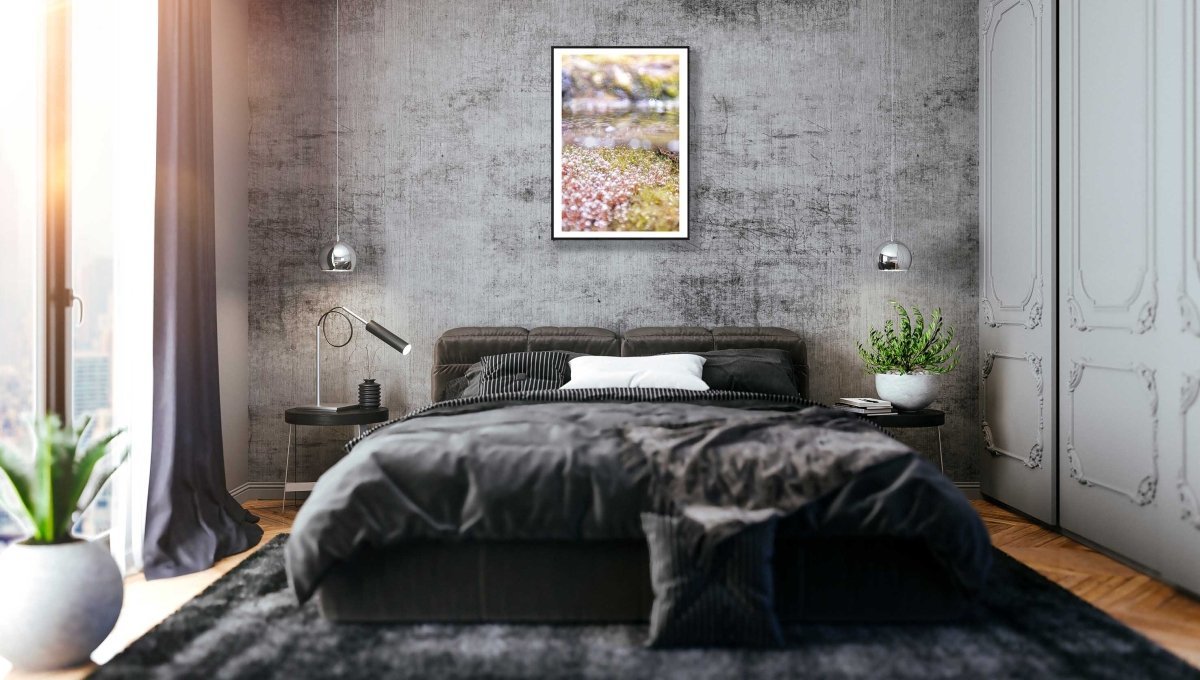 Fine art print of a close-up of underwater spring growth, black-framed on a grey stone wall above a bed in a bedroom.