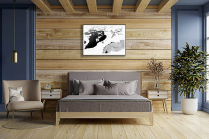 Framed aerial black and white bog photo, contrasting frozen and thawed ponds, five stunted spruces, wooden bedroom wall.