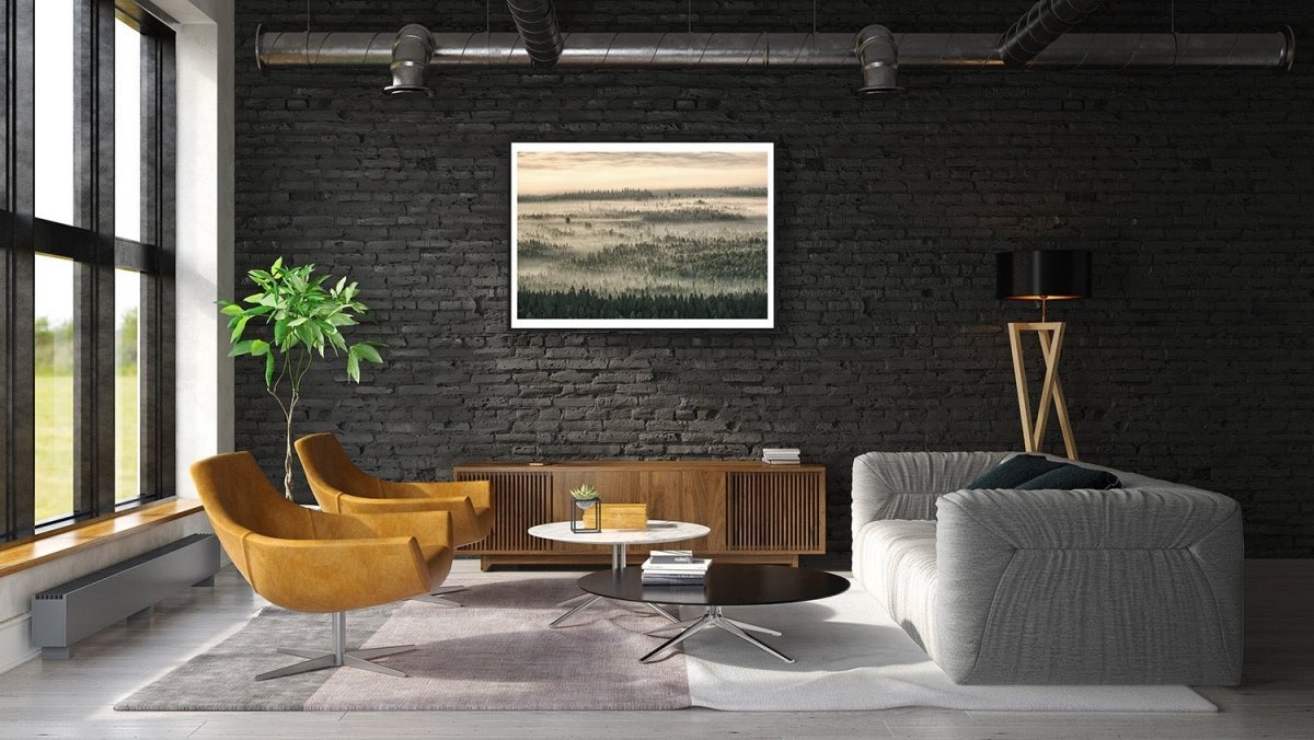 Framed aerial photo of northern forest shrouded in mist and clouds, morning sunlight, black brick living room wall.