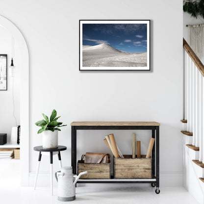 Framed arctic highland moonlight photo, snowy fells, starry sky, white living room wall.