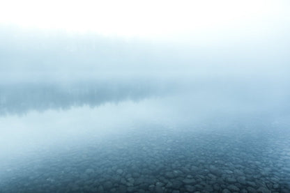 Misty northern lake reflecting forest at blue hour, minimalist palette.