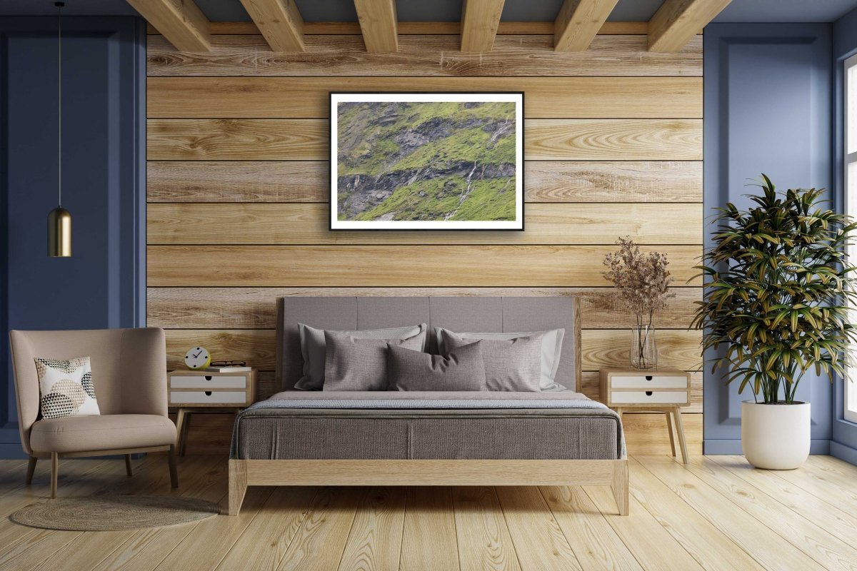Framed photo of meltwater trickling down rocky Norwegian mountain, wooden bedroom wall.