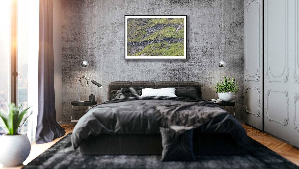Black-framed photo of meltwater trickling down rocky Norwegian mountain, grey stone bedroom wall.