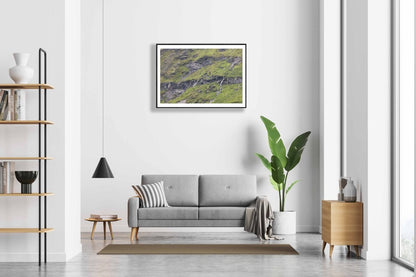 Framed photo of meltwater trickling down rocky Norwegian mountain, white living room wall.