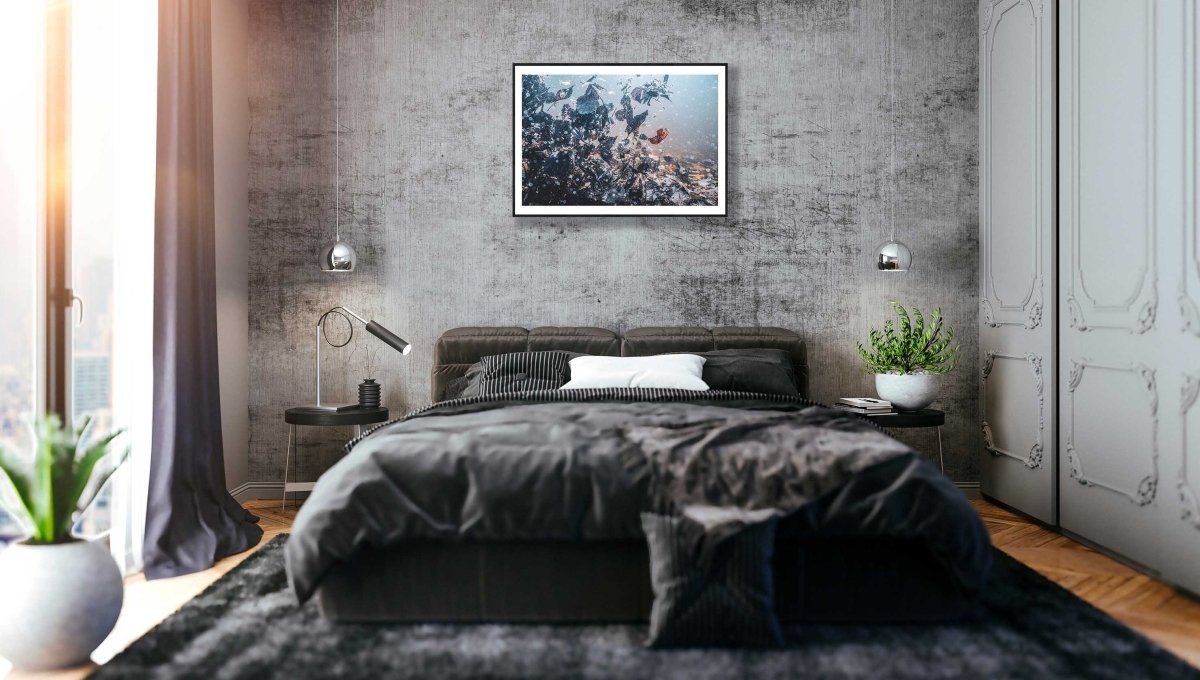 Underwater swirling autumn leaves photo, black-framed on grey stone bedroom wall above bed.