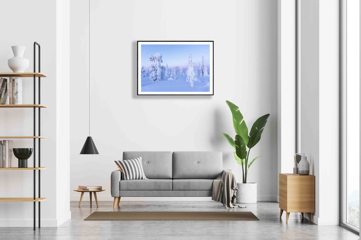 Framed photo of snowy fairy-tale trees in pastel Arctic landscape, white living room wall.
