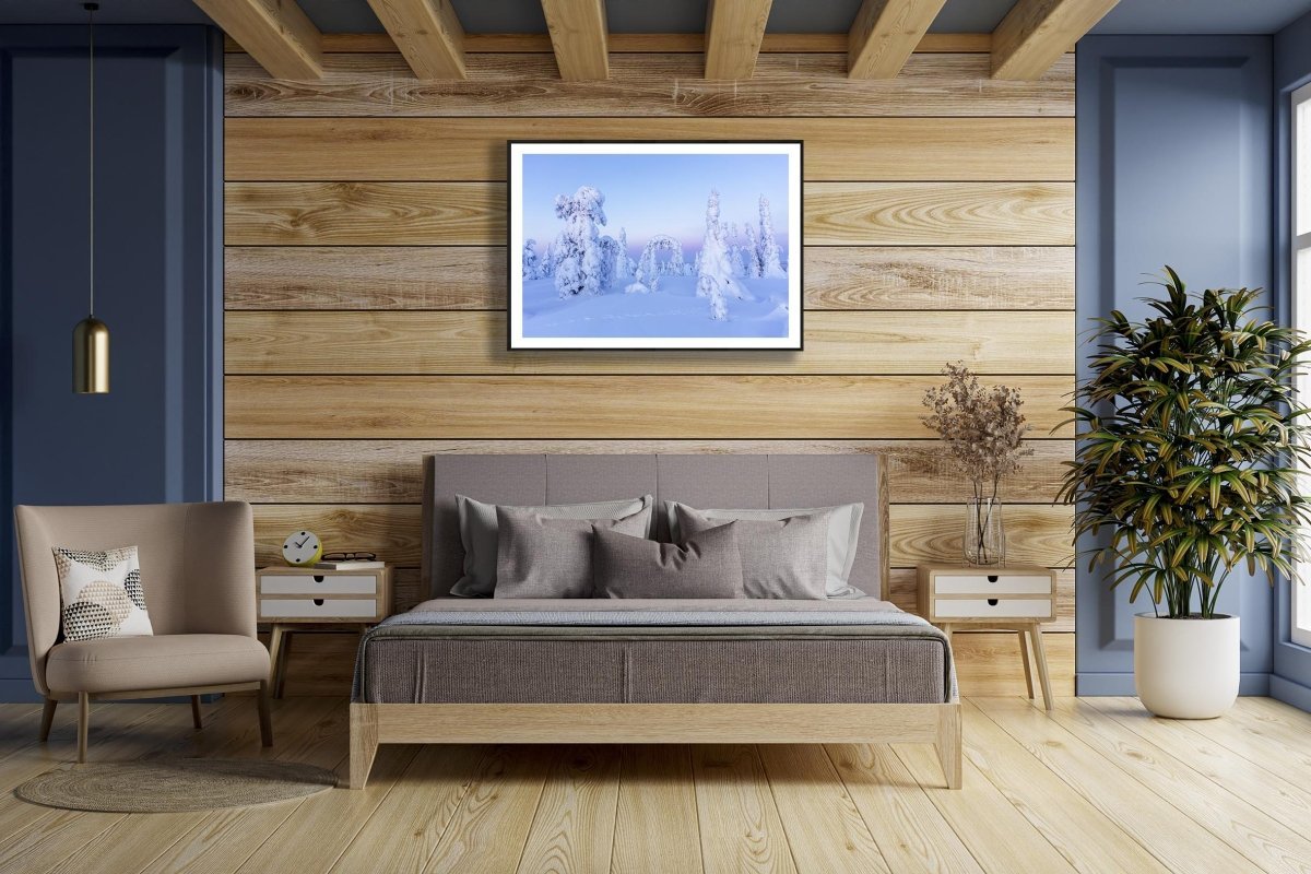 Framed photo of snowy fairy-tale trees in pastel Arctic landscape, wooden bedroom wall.