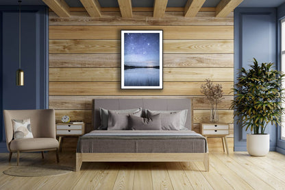 Framed fine art photo of starry night reflected on tranquil lake in northern Finland, wooden bedroom wall.