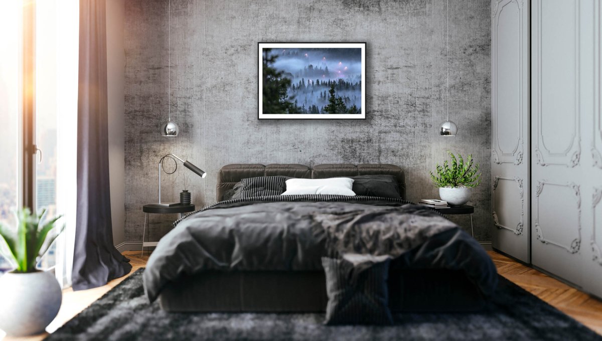 Framed photo of fog-covered forest with winding road and streetlights, landscape fading in the mist, grey stone bedroom wall.