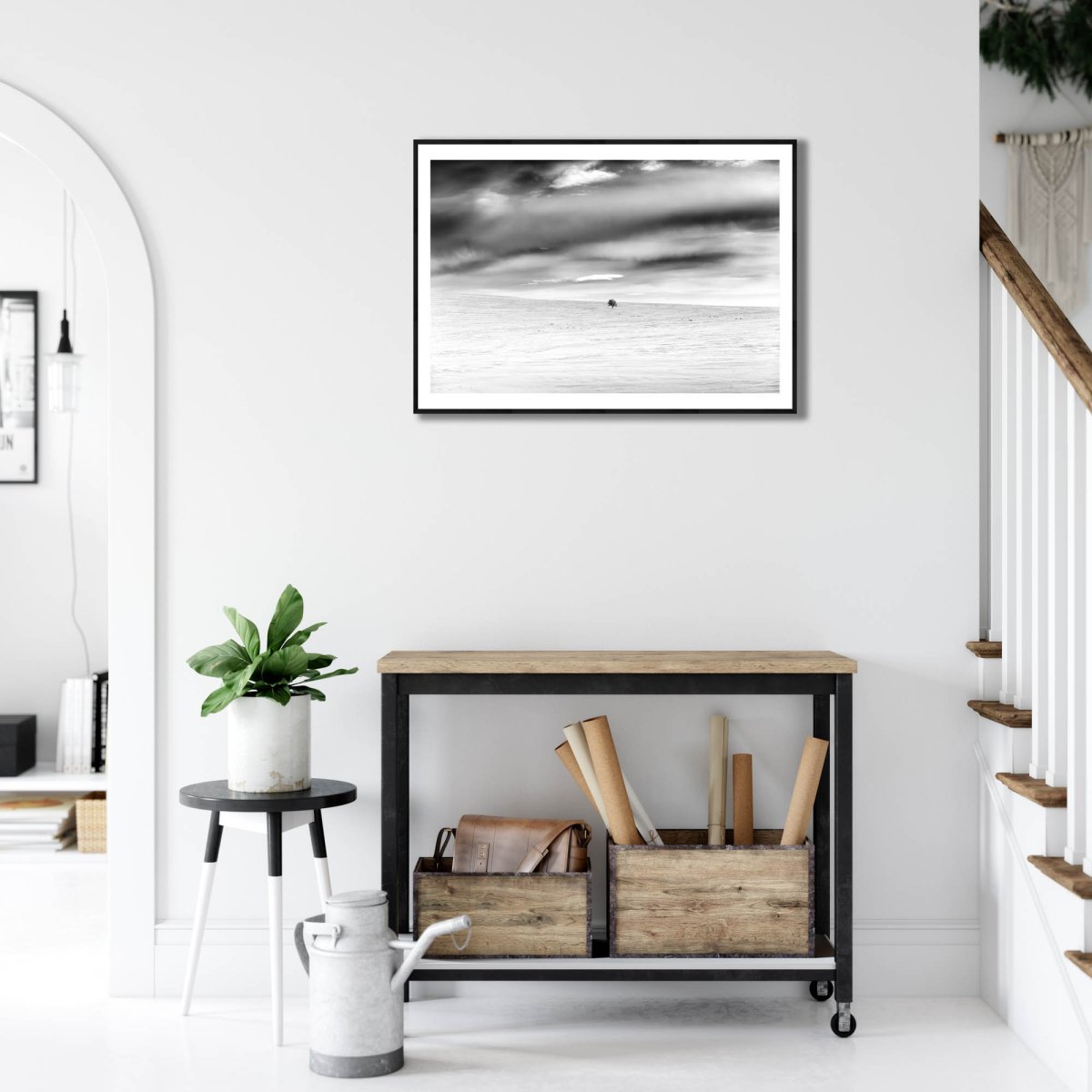 Framed black and white photo of mountain birch standing firm in frozen Arctic wilderness, white living room wall.