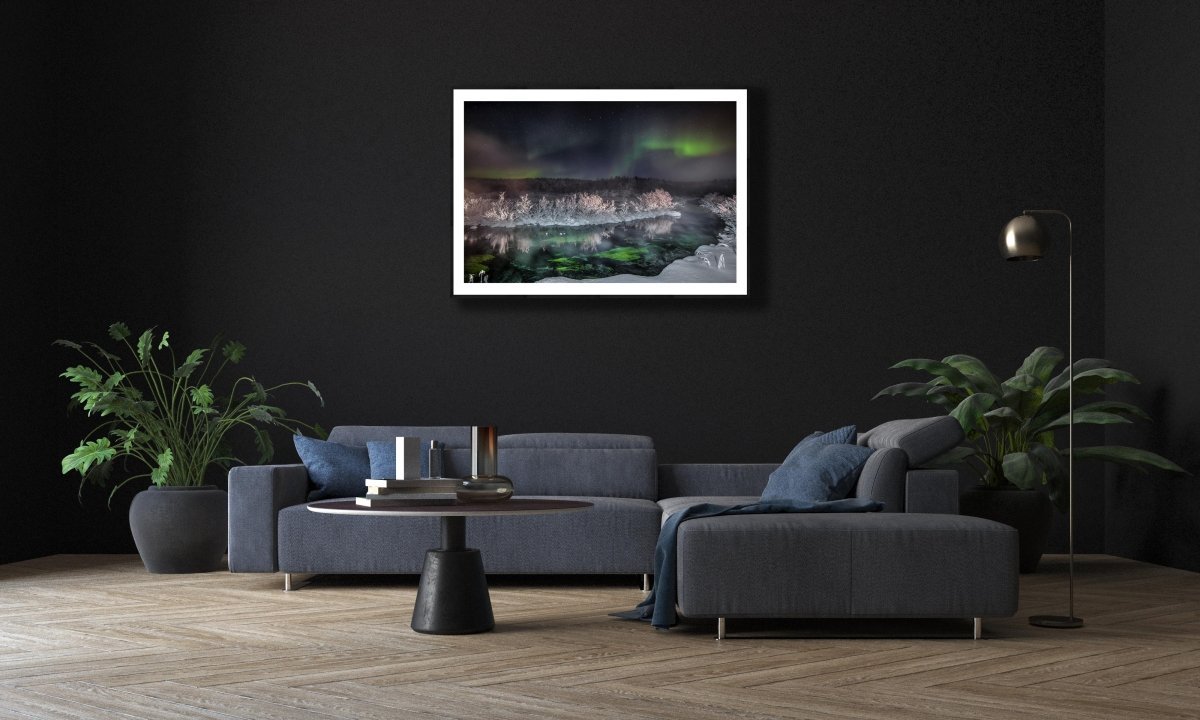 Framed photo of Northern Lights over steaming Arctic river, black living room wall above sofa.