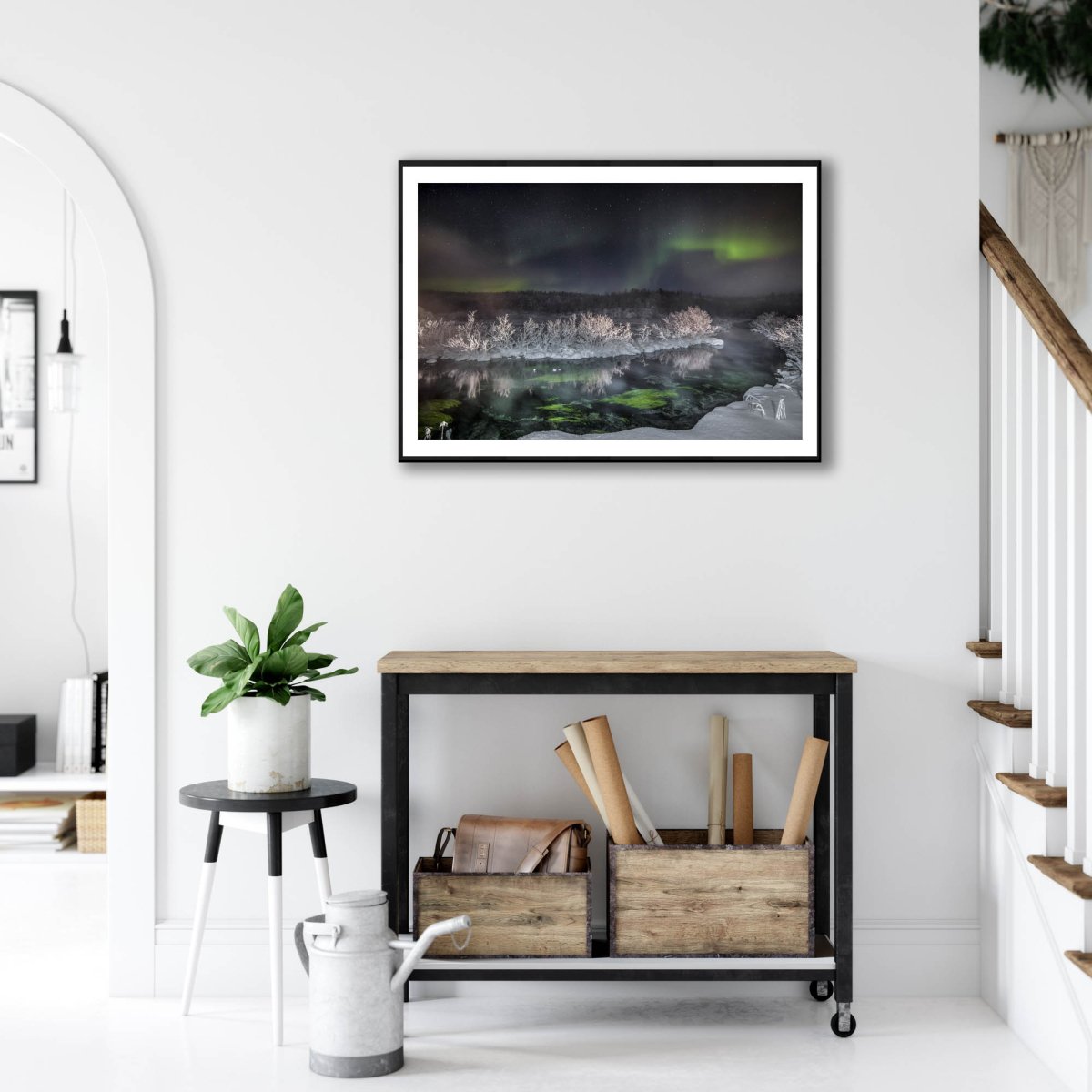 Framed photo of Northern Lights over steaming Arctic river, white living room wall above desk.
