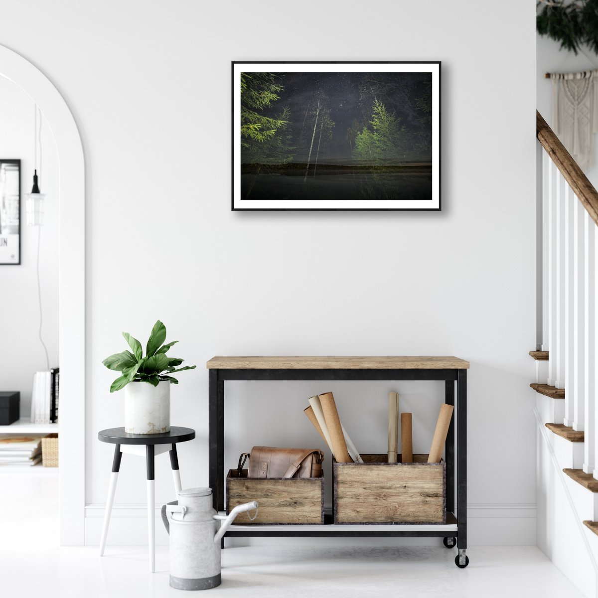 Fine art print of a nocturnal forest and lakeside double exposure, hung above a desk in a living room.