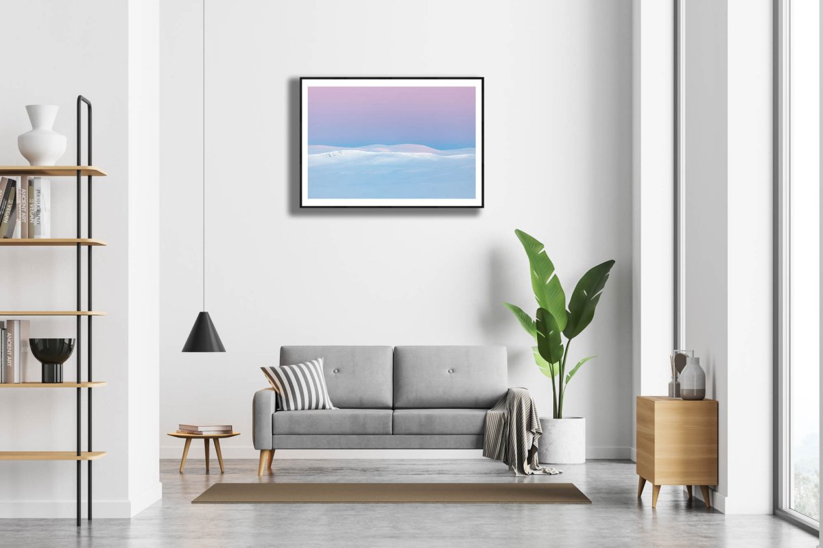 Framed photo of Arctic highlands after polar night, sun rising, pastel hues, white living room wall.
