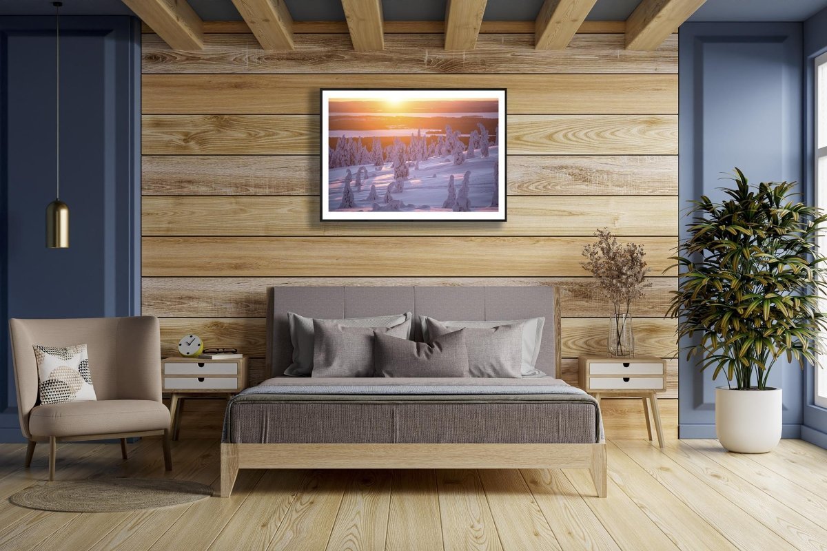 Snow-covered Riisitunturi, purple sunrise, on wooden wall above bed.